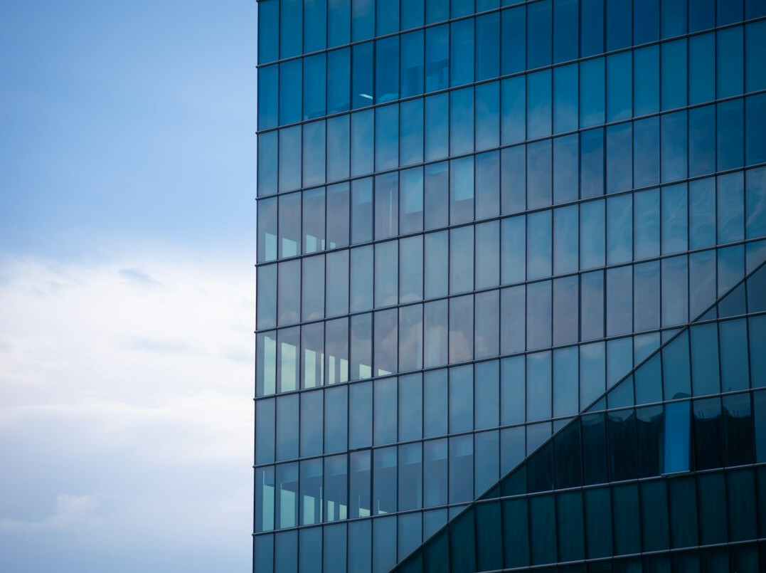 Modern glass office building facade against the sky